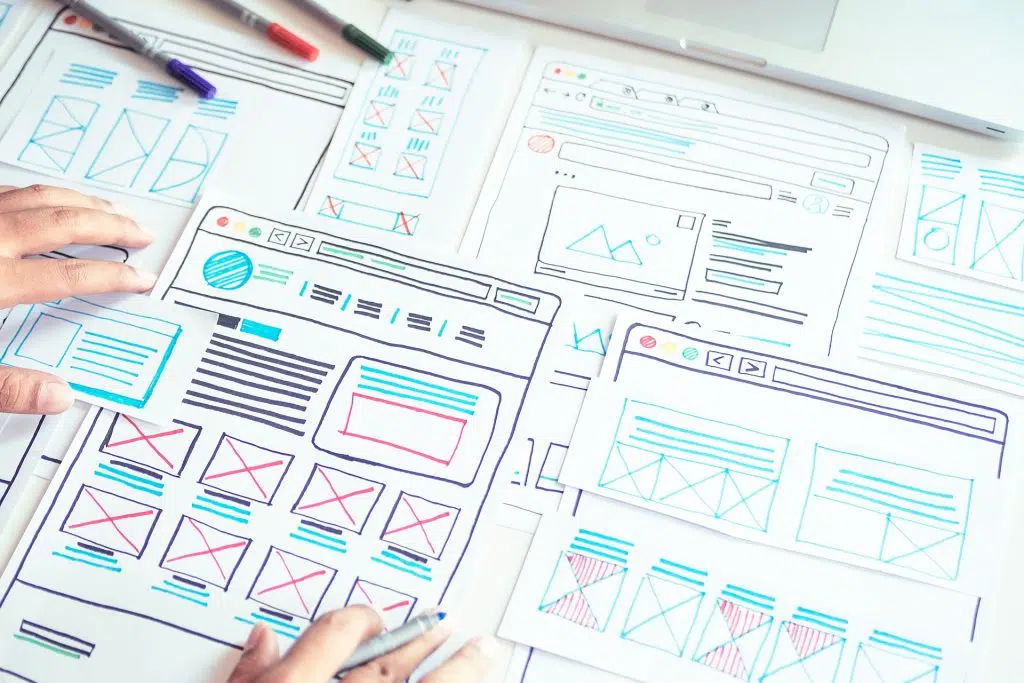 Handgezeichnete Wireframes für Website-Layouts auf Papier, Symbolbild für individuelle WordPress-Themes